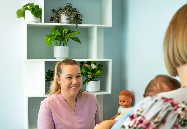 Wizyta niemowlęcia - rodzic z dzieckiem i fizjoterapeutka